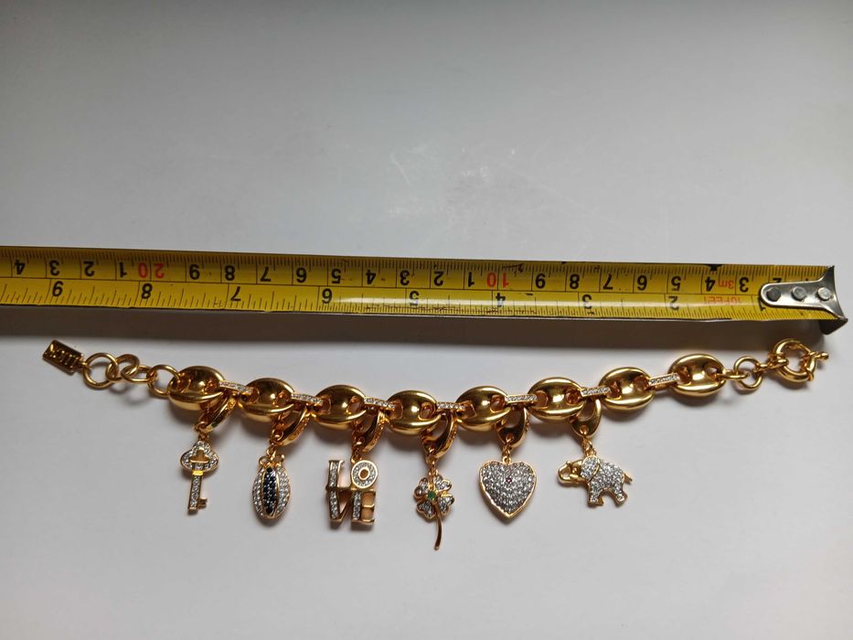 Brățară cu talismane interschimbabile „Love-Luck” de la Galería del Coleccionista, placată cu aur și decorată cu cristale Swarovski, zafire și rubine