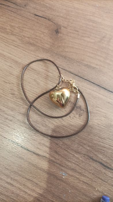 Гердан със лъскаво жълто сърце.