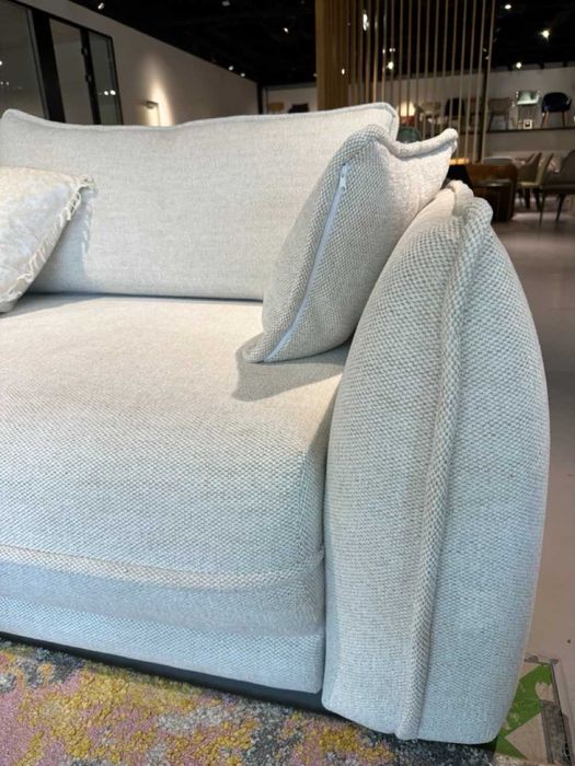 Canapea extensibila, in forma de L, cu sezlong pe partea dreapta, pat 160x200 cm, tapiterie crem deschis, brate cu detaliu de cusatura.