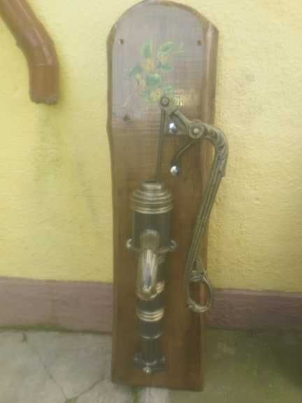 Fantana arteziana din fonta asezata pe un suport de lemn pictata