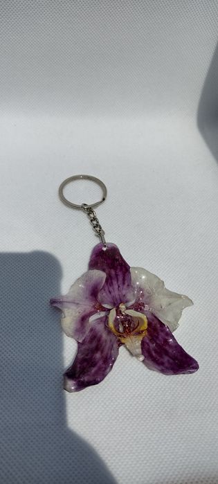 Ключодържател или аксесоар за чанта с естествен цвят на орхидея.