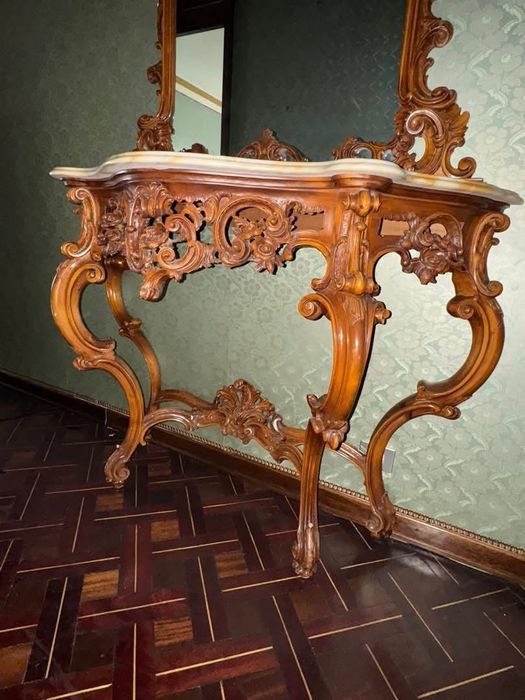 Consolă cu oglindă în stíl clasic baroc, realizată din Lemn masiv bogat sculptat manual, cu blat dín marmură naturală. Set impunător şi rafinat