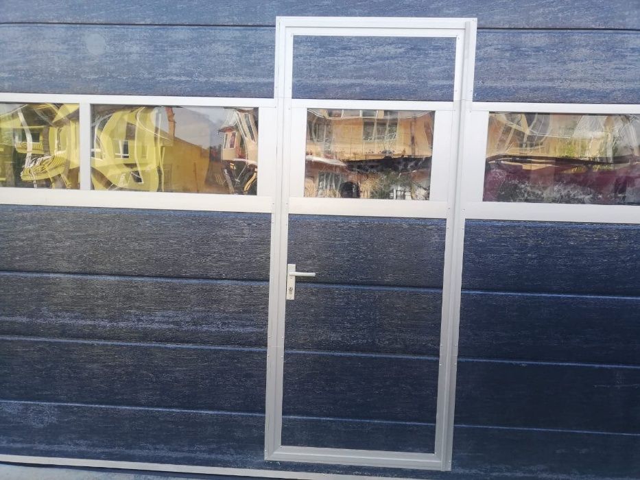 Usi de garaj cu acces pietonal si panou vitrat