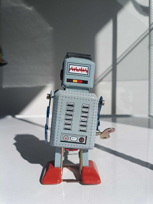 Робот, тенекиена играчка, навива се с ключ и се движи.