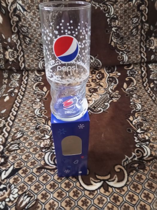 Секлянный стакан с логотипом Pepsi.