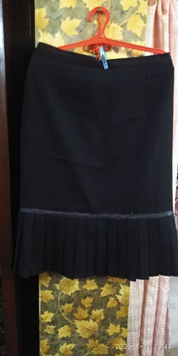 Юбка черная. Внизу складки.