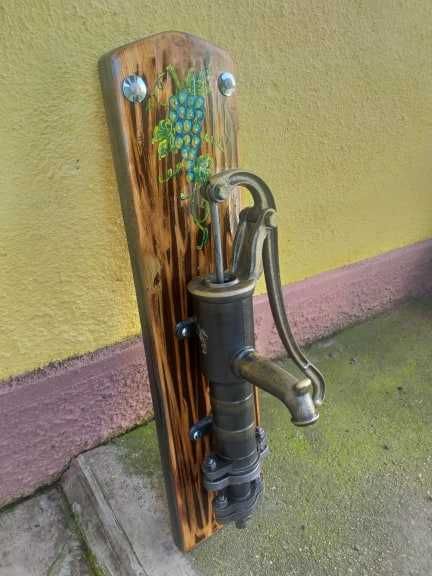 Fantana vintage din fonta asezata pe un suport de lemn