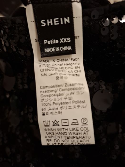 Fusta mini cu peiete, neagra, cu pantaloni scurti pe dedesubt.