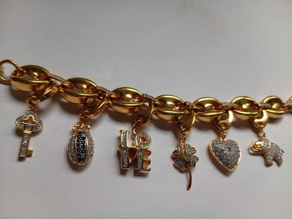 Brățară cu talismane interschimbabile „Love-Luck” de la Galería del Coleccionista, placată cu aur și decorată cu cristale Swarovski, zafire și rubine