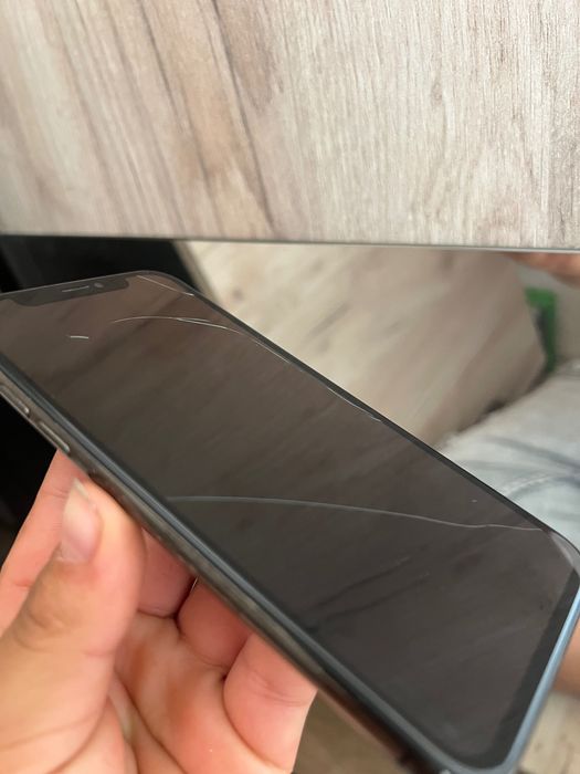 iPhone X cu spatele spart și cu mizerie în portul de încărcare