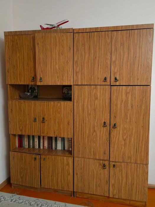 Диван уголок, два кресла и книжный шкаф.