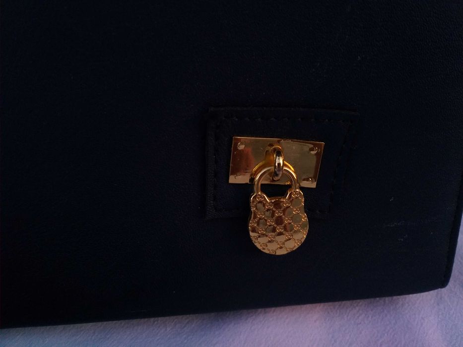 Нова дамска, тъмносиня чанта със златисти елементи.