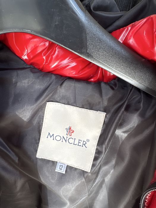 Geacă Moncler roșie, model puffer, cu glugă și detalii Moncler pe glugă.