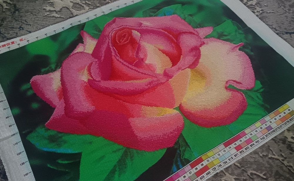 Вышивка крестом, изображающая крупный план розовой розы.