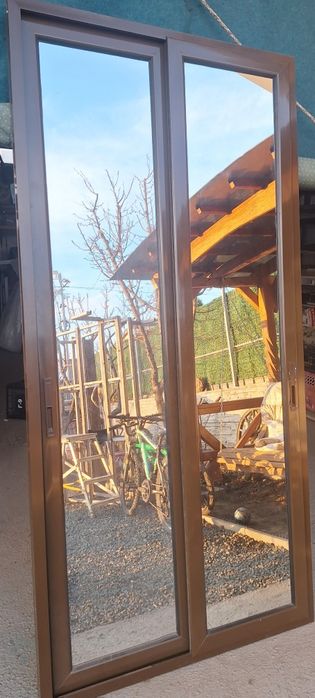 Ușă culisantă dublă, de culoare maro cu oglinda pe o parte