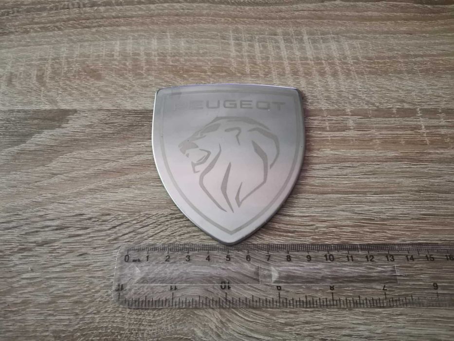 бяла метална емблема Peugeot с новото лого