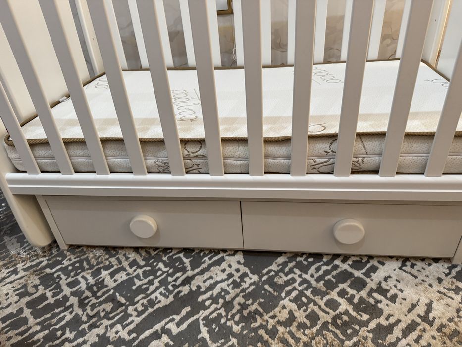 Люлеещо дървено легло с матрак и чекмеджета за съхранение.