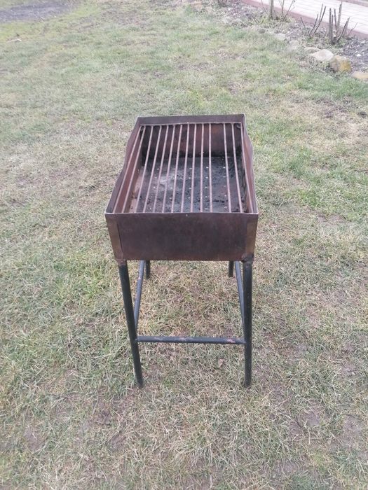 Grătar de inox, picioare de fier, 45x31 cm. 
Are lipsa o bara din gril