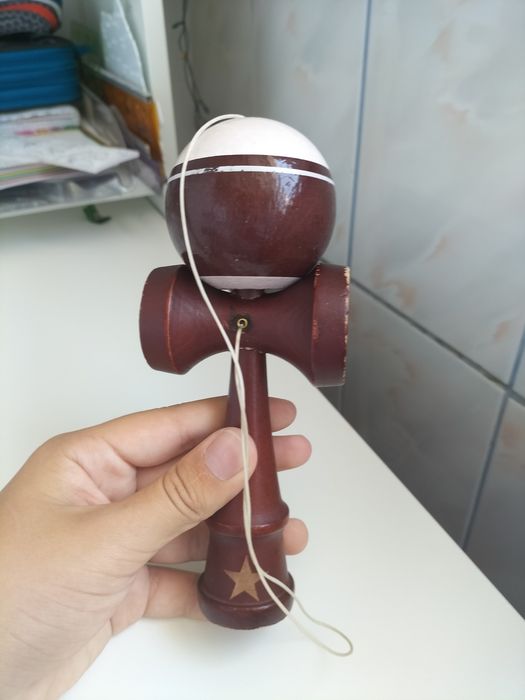 Pachetul vine cu o kendama x puțin uzată care vine cu o ață in plus