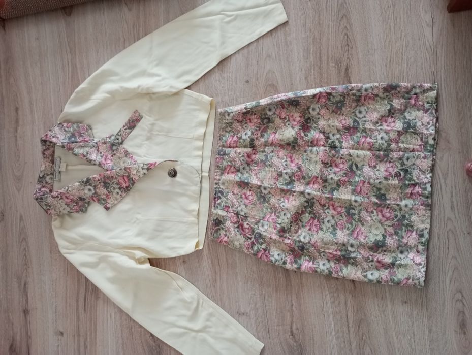 Compleu format din bluză cu garnitură florală de mătase și fustă .