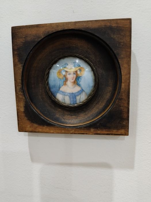 Миниатюрен портрет в рамка, върху по-голяма, дълбока дървена основа.