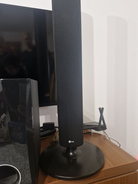 SIstem Home Cinema LG 5.1 compus din boxe verticale de tip tallboy, un subwoofer, o boxă centrală, două boxe satelit mici poziționate pe unitate