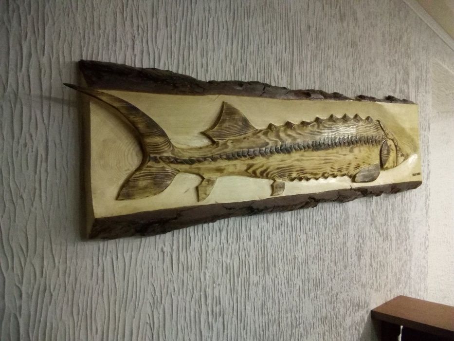 Осётр вырезанный на стволе дерева.