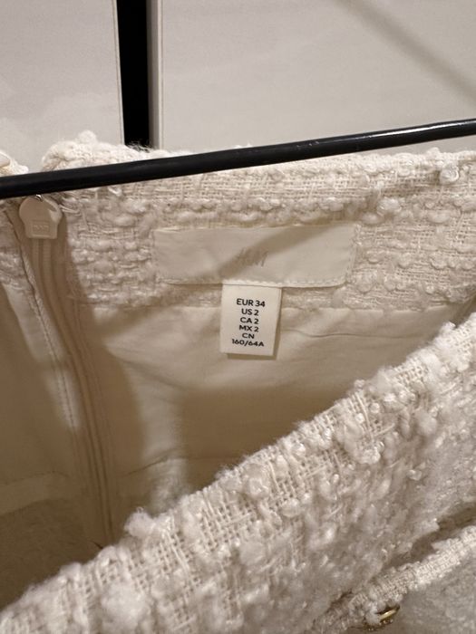 Бяла къса пола с висока талия и разкроен силует.