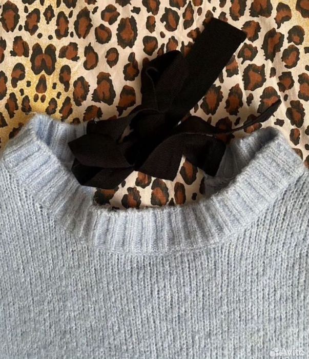 Свитер голубого цвета сзади есть завязка