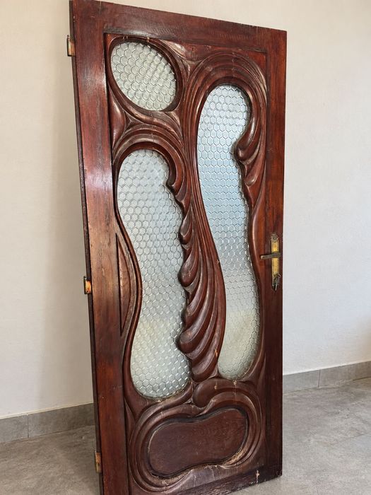 Ușă veche din lemn sculptat, cu sticlă decorativă și feronerie