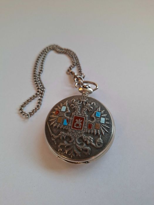 Ceas de buzunar mecanic vintage produs de celebra fabrică Sovietică Molnija(Молния) din URSS, decorat pe capac cu vulturul bicefal și scuturi emailate