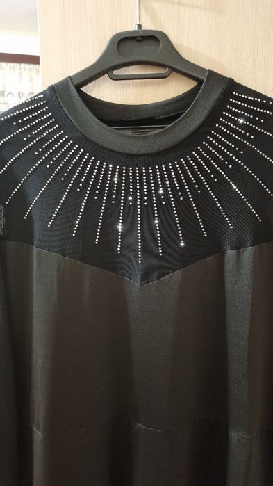 Рокля с мрежест детайл на деколтето и ръкавите, гарниран с камъчета.