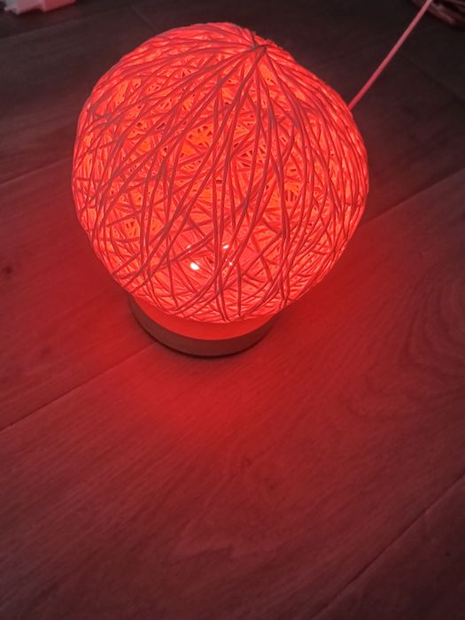 lampă de masă are un abajur sferic din ratan țesut manual și o bază din lemn.