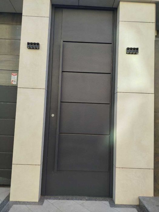 Входные двери в едином стиле с секционными воротами.