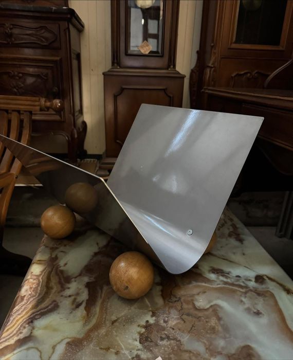 Suport modern pentru ziare și reviste, realizat din metal cu finisaj gri și bază decorativă din lemn masiv. Design minimalist, stabil și practic