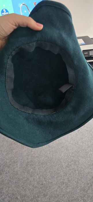 Зимна вълнена тъмно зелена дамска шапка.