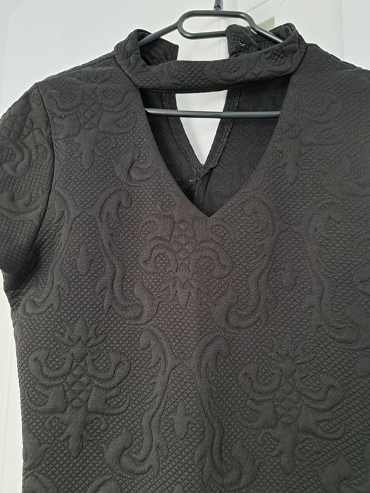 Rochie neagra cu fermoar pe spate.