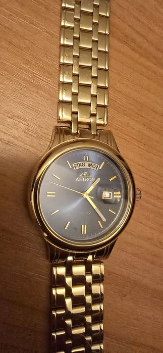 Acesta este un ceas Astron cuarț în tonuri de aur, cu un cadran albast