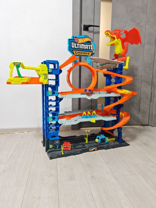 Mega Lot Hot Wheels: Ultimate Garage T-Rex, Piste, 14 Monster Trucks + 220 Mașinuțe