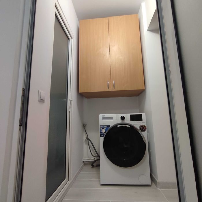 Dulap suspendat deasupra mașini de spălat.