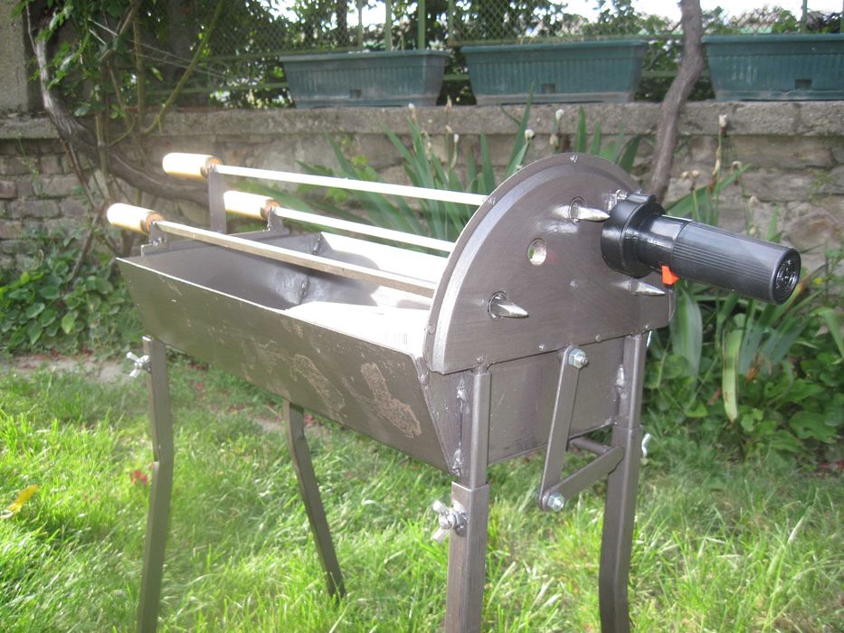 Барбекю на дървени въглища с въртящи се шишове и скара.