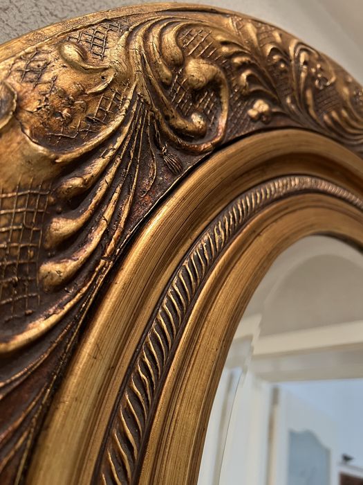 Oglindă ovală decorativă cu ramă aurie sculptată stil baroc (bizotată)