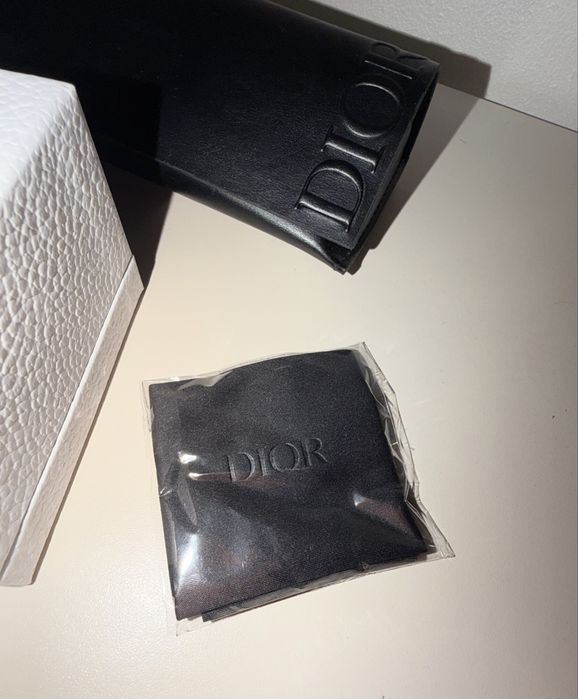 Vând ochelari de soare Dior, model elegant și sofisticat, cu ramă neagră și detalii aurii.