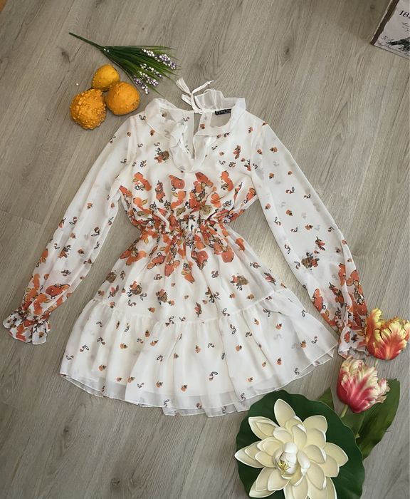 Елегантна рокля с цветя, с леко отворено деколте на гърба.