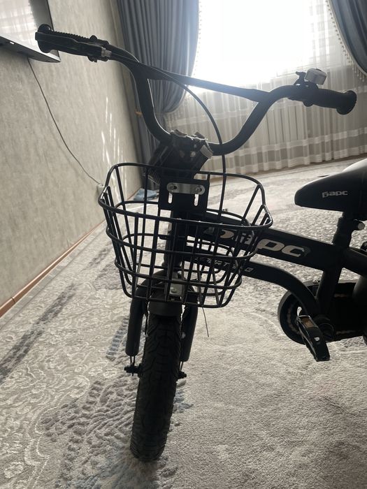 Велосипе жаңа балаға арүалған