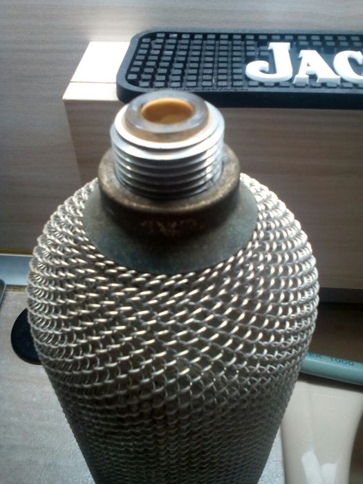 Голяма стъклена бутилка със сифон обвита с алуминий