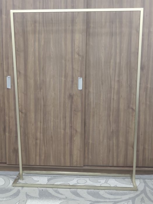 Золотая напольная металлическая вешалка.