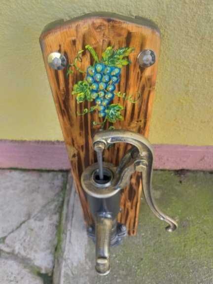 Fantana vintage din fonta asezata pe un suport de lemn