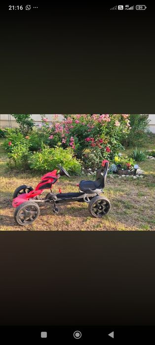 Kart cu pedale roșu pentru copii.