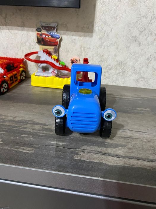 Продам синий трактор с красным ковшом .